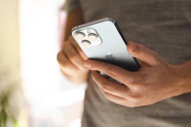 CRACOW, POLAND - Ekim 2021: Yeni iPhone 13 Pro kullanan adam SIerra mavisi, kamera setine yakın çekim
