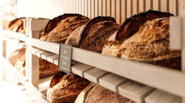 Ekşi ekmek pastanenin raflarında yatıyor - gerçek bir rustik zanaatkar ekmeği - 3 boyutlu resim