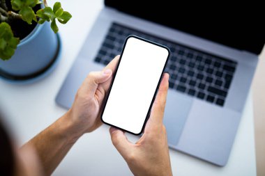 Akıllı telefon boş ekran çerçeve kullanan adam - üst görünüm, arka planda dizüstü bilgisayar klavyesi