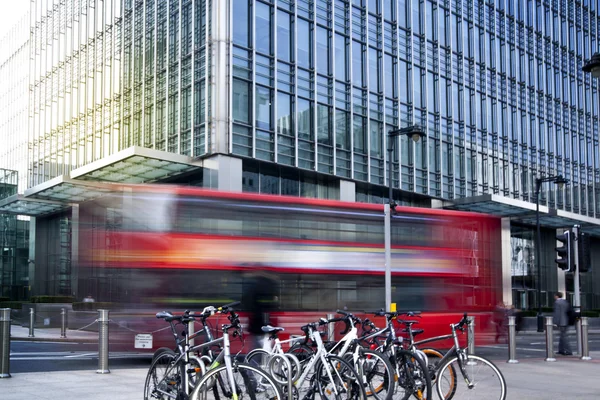 LONDRES, Reino Unido - 10 de marzo de 2014: Canary Wharf business aria. Transporte público Famoso autobús rojo de dos pisos y bicicletas que traen viajeros al trabajo — Foto de Stock