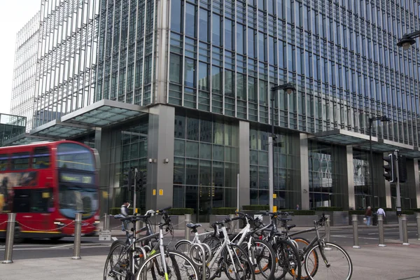 London, Velká Británie - 10 březen 2014: Canary Wharf podnikání árie. Veřejná doprava slavné Red Double Decker Bus a kola přináší dojíždějících do práce — Stock fotografie