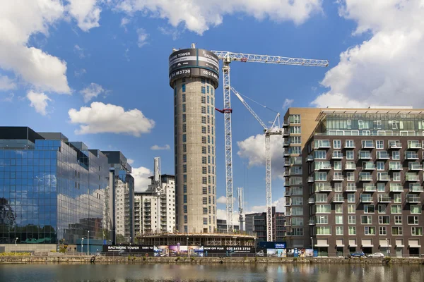 LONDRES, Reino Unido - 7 de junio de 2014: Edificio con grúas en Canary Wharf aria. Elevando la nueva torre residencial más alta en 43 plantas en el aria de la oficina de negocios — Foto de Stock