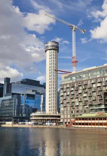 LONDRES, Reino Unido - 7 de junio de 2014: Edificio con grúas en Canary Wharf aria. Elevando la nueva torre residencial más alta en 43 plantas en el aria de la oficina de negocios — Foto de Stock