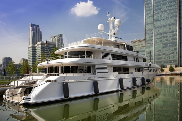 LONDRES UK - 7 DE MAYO DE 2014: Yate privado con base en Canary Wharf, contra modernos rascacielos de cristal — Foto de Stock