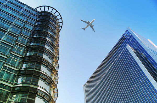 LONDON, UK - JUNE 30, 2014: Aircraft over the London's skyscrapers going to land in the City airport