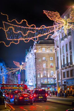 Londra İngiltere - 18 Kasım 2021: Piccadilly Caddesi 'nde festival dekorasyonları ve Noel ışıkları. Bir sürü araba ve karşıdan karşıya geçen insanlar.