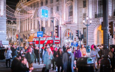 Londra İngiltere - 18 Kasım 2021: Londra 'da festival dekorasyonları ve Noel ışıkları. Piccadilly Sirki 'nde insanlar karşıdan karşıya geçiyor.