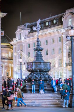 Londra İngiltere - 18 Kasım 2021: Londra 'da festival dekorasyonları ve Noel ışıkları. Piccadilly Sirki 'nde insanlar karşıdan karşıya geçiyor.