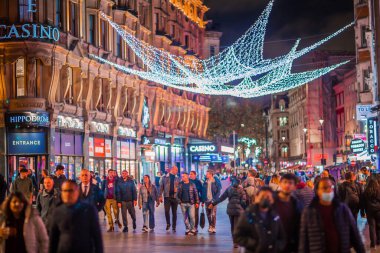 Londra İngiltere - 18 Kasım 2021: Leicester Meydanı festival süslemeleri ve Noel ışıkları. Gece hayatı, insanlar yürür, barlar, sinemalar, restoranlar ve eğlence merkezleri Londra 'da