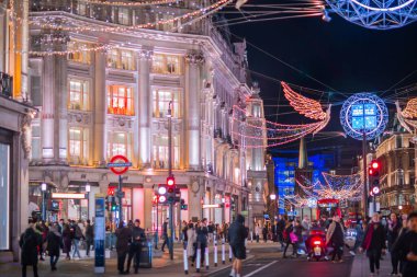 Londra İngiltere - 18 Kasım 2021: Regent Caddesi 'nde festival dekorasyonları ve Noel ışıkları, arabalar, otobüsler ve sokakta yürüyen insanlar
