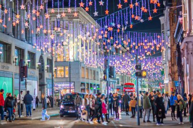 Londra İngiltere - 18 Kasım 2021: Londra, Oxford Caddesi 'nin gece hayatı. Londra 'da Noel süslemeleri ve Noel ışıkları. Sokakta bir sürü insan yürüyor. 