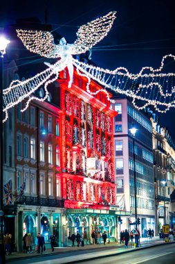 Londra İngiltere - 18 Kasım 2021: Fortnum Mason 18. yüzyıl mağazası, şenlik dekorasyonları ve Noel ışıkları. Piccadilly caddesinde karşıdan karşıya geçen insanlar var.