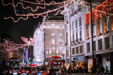 Londra İngiltere - 18 Kasım 2021: Piccadilly Caddesi 'nde festival dekorasyonları ve Noel ışıkları. Bir sürü araba ve karşıdan karşıya geçen insanlar.