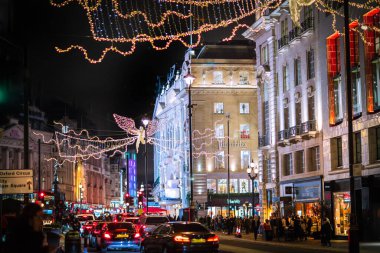 Londra İngiltere - 18 Kasım 2021: Piccadilly Caddesi 'nde festival dekorasyonları ve Noel ışıkları. Bir sürü araba ve karşıdan karşıya geçen insanlar.