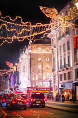 Londra İngiltere - 18 Kasım 2021: Piccadilly Caddesi 'nde festival dekorasyonları ve Noel ışıkları. Bir sürü araba ve karşıdan karşıya geçen insanlar.