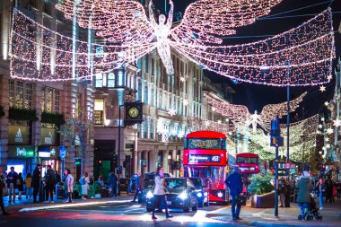 Londra İngiltere - 18 Kasım 2021: Piccadilly sirkinde festival dekorasyonları ve Noel ışıkları, arabalar, otobüsler ve sokakta yürüyen insanlar