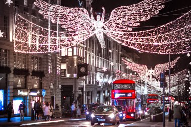 Londra İngiltere - 18 Kasım 2021: Piccadilly sirkinde festival dekorasyonları ve Noel ışıkları, arabalar, otobüsler ve sokakta yürüyen insanlar
