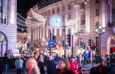 Londra İngiltere - 18 Kasım 2021: Piccadilly sirkinde festival dekorasyonları ve Noel ışıkları, arabalar, otobüsler ve sokakta yürüyen insanlar