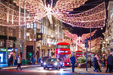 Londra İngiltere - 18 Kasım 2021: Piccadilly sirkinde festival dekorasyonları ve Noel ışıkları, arabalar, otobüsler ve sokakta yürüyen insanlar