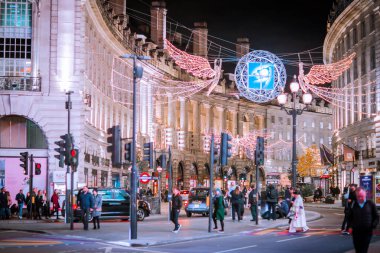 Londra İngiltere - 18 Kasım 2021: Piccadilly sirkinde festival dekorasyonları ve Noel ışıkları, arabalar, otobüsler ve sokakta yürüyen insanlar