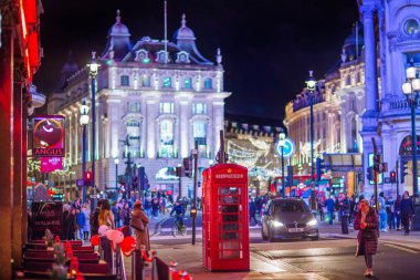 Londra İngiltere - 18 Kasım 2021: Piccadilly sirkinde festival dekorasyonları ve Noel ışıkları, arabalar, otobüsler ve sokakta yürüyen insanlar