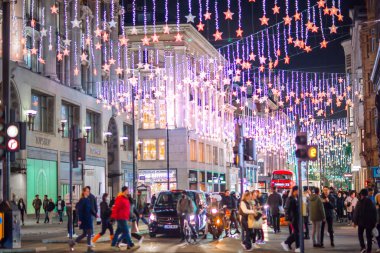 Londra İngiltere - 18 Kasım 2021: Oxford caddesinde festival dekorasyonları ve Noel ışıkları, arabalar, otobüsler ve sokakta yürüyen insanlar. Londra 'nın gece hayatı 