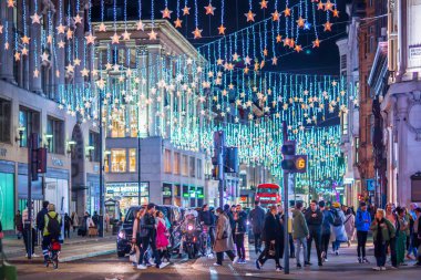 Londra İngiltere - 18 Kasım 2021: Oxford caddesinde festival dekorasyonları ve Noel ışıkları, arabalar, otobüsler ve sokakta yürüyen insanlar. Londra 'nın gece hayatı 