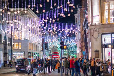 Londra İngiltere - 18 Kasım 2021: Oxford caddesinde festival dekorasyonları ve Noel ışıkları, arabalar, otobüsler ve sokakta yürüyen insanlar. Londra 'nın gece hayatı 