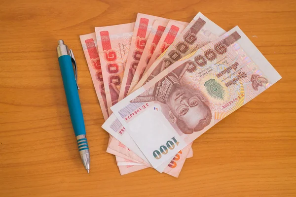 Money and pen on wood — Stock Photo, Image