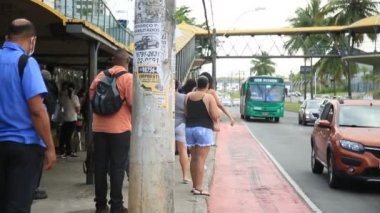 Salvador, Bahia, Brezilya - 30 Eylül 2021: İnsanlar Salvador 'da bir otobüs durağında toplu taşıma beklerken görüldü.