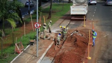 Salvador, Bahia, Brezilya - 26 Mayıs 2021: Salvador şehrinde BRT sisteminin araçları için özel bir şerit inşaatı sırasında sivil inşaat işçileri görüldü..