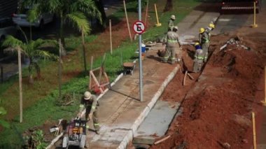 Salvador, Bahia, Brezilya - 26 Mayıs 2021: Salvador şehrinde BRT sisteminin araçları için özel bir şerit inşaatı sırasında sivil inşaat işçileri görüldü..
