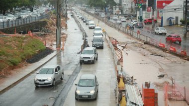 Salvador, Bahia, Brezilya - 21 Ekim 2021: Salvador 'daki Itaigara Mahallesi' nde BRT sistem araçları için özel bir şerit inşaatı boyunca araçlar geçer..