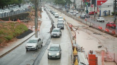 Salvador, Bahia, Brezilya - 21 Ekim 2021: Salvador 'daki Itaigara Mahallesi' nde BRT sistem araçları için özel bir şerit inşaatı boyunca araçlar geçer..