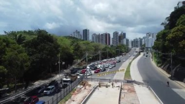 Salvador, Bahia, Brezilya - 10 Kasım 2021: Salvador şehrinde BRT taşıma sisteminin araçları için özel bir şerit inşaatı boyunca araç hareketinin hava görüntüsü.