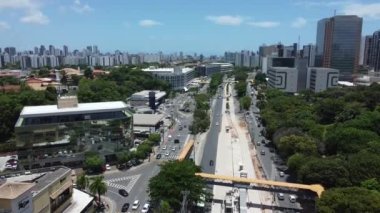 Salvador, Bahia, Brezilya - 10 Kasım 2021: Salvador şehrinde BRT taşıma sisteminin araçları için özel bir şerit inşaatı boyunca araç hareketinin hava görüntüsü.