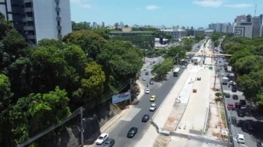 Salvador, Bahia, Brezilya - 10 Kasım 2021: Salvador şehrinde BRT taşıma sisteminin araçları için özel bir şerit inşaatı boyunca araç hareketinin hava görüntüsü.