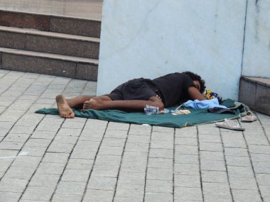 Salvador, Bahia, Brezilya - 20 Kasım 2021: Evsiz kişi Salvador şehir merkezindeki caddenin penceresinin önünde uyurken görüldü.