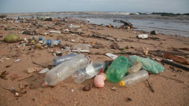 Salvador, Bahia, Brezilya - 30 Kasım 2021: Plastik şişe ve yığın çöp, Salvador şehrinin Rio Camurigipe ağzı yakınlarındaki Costa Azul sahilinde görüldü..