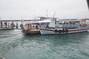 Salvador, Bahia, Brezilya - 7 Aralık 2021: Vera Cruz şehrindeki Todos dos Santos körfezinden geçerek Mar Grande 'ye doğru Salvador' u geçmek için bir rıhtımda gemiye binen yolcular.