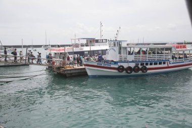 Salvador, Bahia, Brezilya - 7 Aralık 2021: Vera Cruz şehrindeki Todos dos Santos körfezinden geçerek Mar Grande 'ye doğru Salvador' u geçmek için bir rıhtımda gemiye binen yolcular.