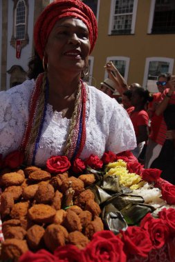 Salvador, Bahia, Brezilya - 4 Aralık 2015: Baiana, Salvador 'daki Pelourinho kentinde Santa Barbara' nın onuruna ayin sırasında acaraje taşıdı.
