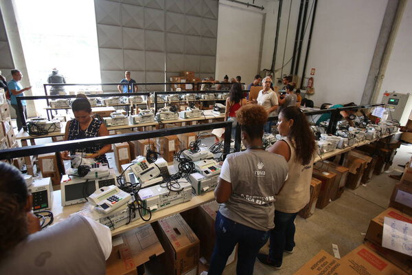 salvador, bahia, brazil - october 17, 2018: employee of the Regional Electoral Court of Bahia works in the procedure for loading and sealing electronic voting machines for elections in the city of Salvador.
