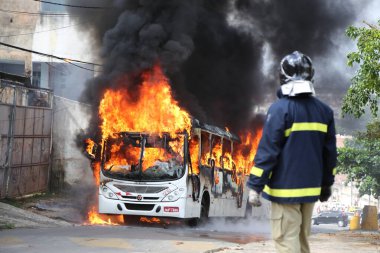 Salvador, Bahia, Brezilya - 23 Ocak 2015: Salvador 'daki Mata Escuro mahallesinde uyuşturucu satıcılarının eylemleri sırasında otobüste itfaiyeciler yangınla mücadele ediyor.