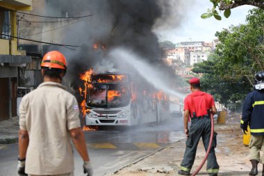 Salvador, Bahia, Brezilya - 23 Ocak 2015: Salvador 'daki Mata Escuro mahallesinde uyuşturucu satıcılarının eylemleri sırasında otobüste itfaiyeciler yangınla mücadele ediyor.