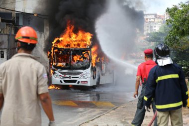 Salvador, Bahia, Brezilya - 23 Ocak 2015: Salvador 'daki Mata Escuro mahallesinde uyuşturucu satıcılarının eylemleri sırasında otobüste itfaiyeciler yangınla mücadele ediyor.