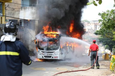 Salvador, Bahia, Brezilya - 23 Ocak 2015: Salvador 'daki Mata Escuro mahallesinde uyuşturucu satıcılarının eylemleri sırasında otobüste itfaiyeciler yangınla mücadele ediyor.