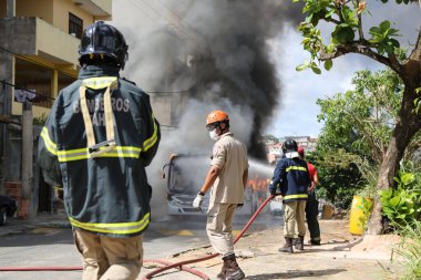 Salvador, Bahia, Brezilya - 23 Ocak 2015: Salvador 'daki Mata Escuro mahallesinde uyuşturucu satıcılarının eylemleri sırasında otobüste itfaiyeciler yangınla mücadele ediyor.