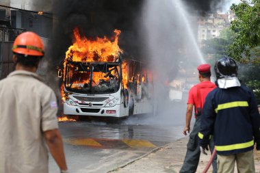 Salvador, Bahia, Brezilya - 23 Ocak 2015: Salvador 'daki Mata Escuro mahallesinde uyuşturucu satıcılarının eylemleri sırasında otobüste itfaiyeciler yangınla mücadele ediyor.
