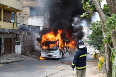 Salvador, Bahia, Brezilya - 23 Ocak 2015: Salvador 'daki Mata Escuro mahallesinde uyuşturucu satıcılarının eylemleri sırasında otobüste itfaiyeciler yangınla mücadele ediyor.